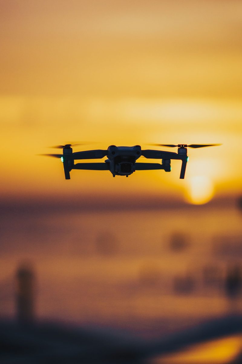 Drone vliegt voor een oranje zonsondergang