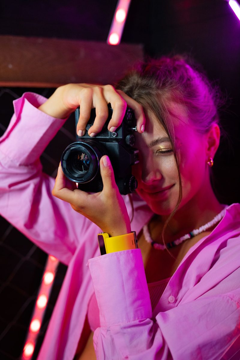 Fotografe met camera in roze licht