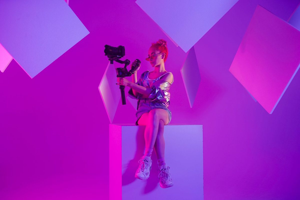 Videograaf met gimbal in een studio met neonlicht
