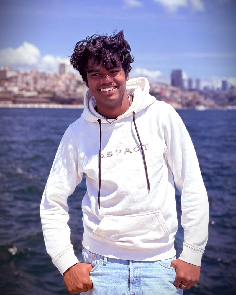 Thomas Deekman, oprichter van LUX Media, in een witte hoodie aan het water